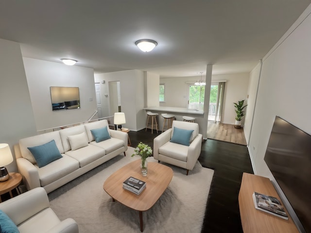 living room with dark hardwood / wood-style floors and an inviting chandelier