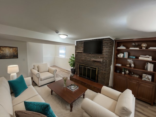 living room featuring light hardwood / wood-style flooring and a brick fireplace