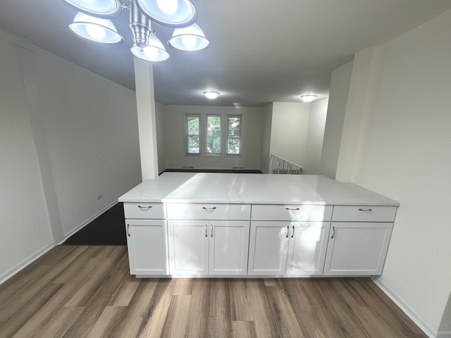 kitchen with white cabinets, dark hardwood / wood-style floors, and kitchen peninsula