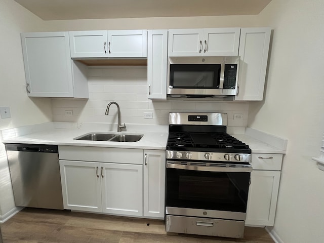 kitchen with sink, white cabinetry, and stainless steel appliances