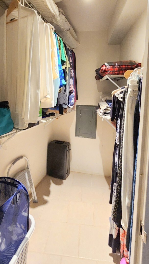 spacious closet featuring electric panel and light tile patterned floors