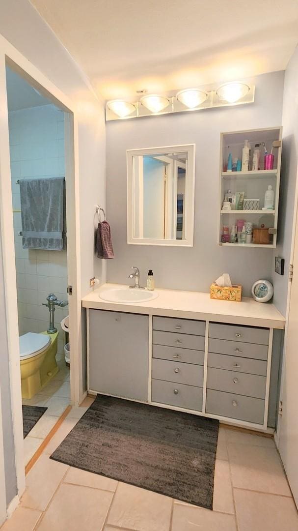 bathroom with toilet, tile patterned floors, and vanity