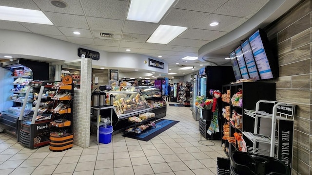 interior space featuring visible vents, a drop ceiling, and tile patterned floors