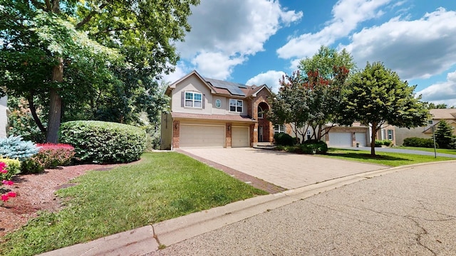 view of front of property featuring a garage, a front yard, and solar panels