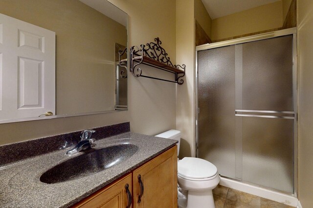 bathroom featuring vanity, toilet, tile patterned floors, and walk in shower