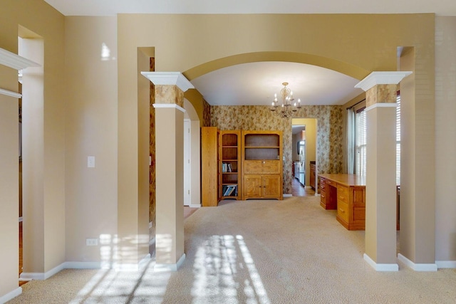 interior space with light carpet, a chandelier, and ornate columns