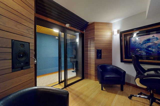 home office with wooden walls and light hardwood / wood-style floors