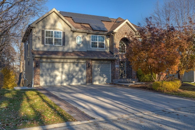 view of front of property with a garage and solar panels