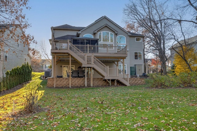 back of property with cooling unit, a wooden deck, a sunroom, and a lawn