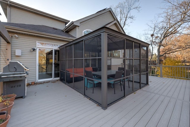 wooden deck with area for grilling and a sunroom