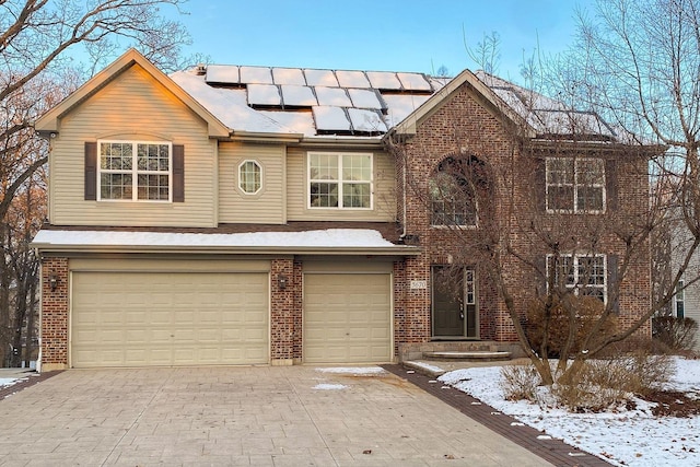 front facade with a garage and solar panels