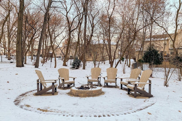 yard layered in snow with an outdoor fire pit