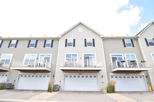 multi unit property featuring central AC, a garage, and a balcony