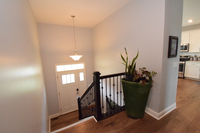 staircase with wood-type flooring and a high ceiling