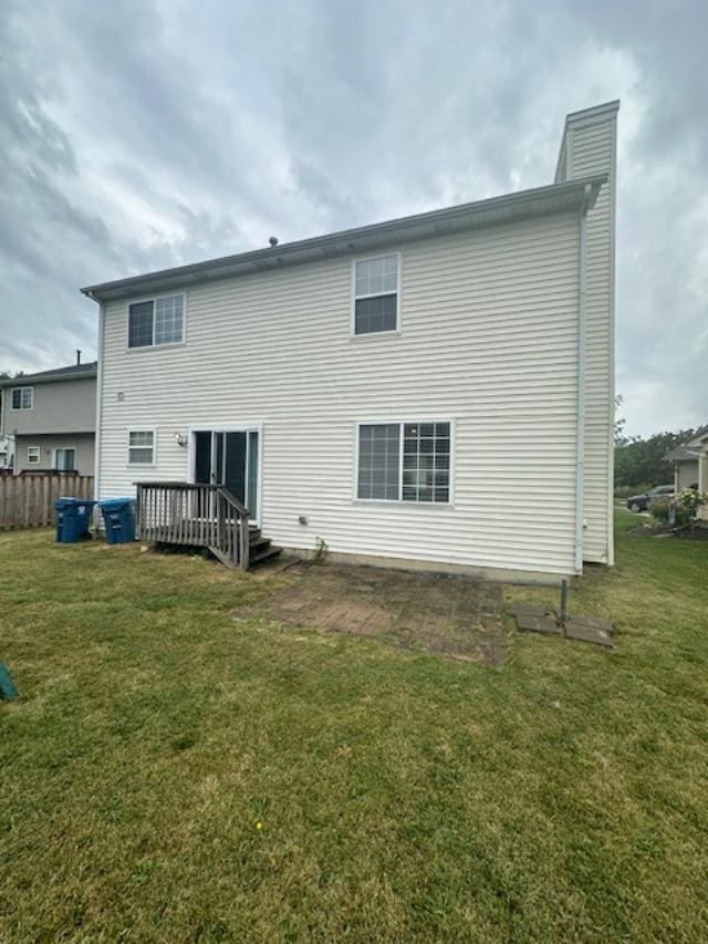 rear view of property with a yard and a deck