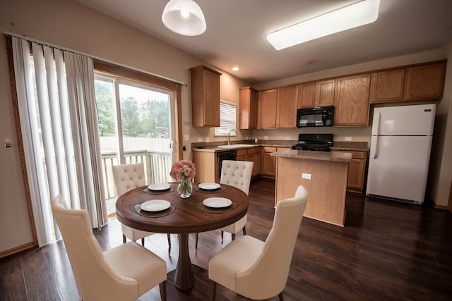 kitchen with a kitchen island, dark hardwood / wood-style floors, and black appliances