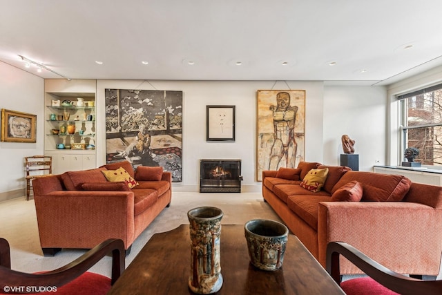 living room with light carpet, built in shelves, and rail lighting