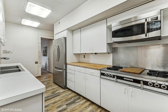 kitchen featuring white cabinetry, sink, stainless steel appliances, and dark hardwood / wood-style floors