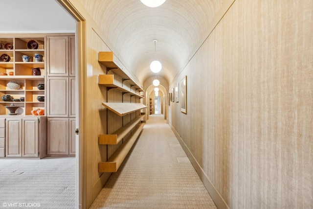 hallway featuring brick ceiling, light carpet, and vaulted ceiling