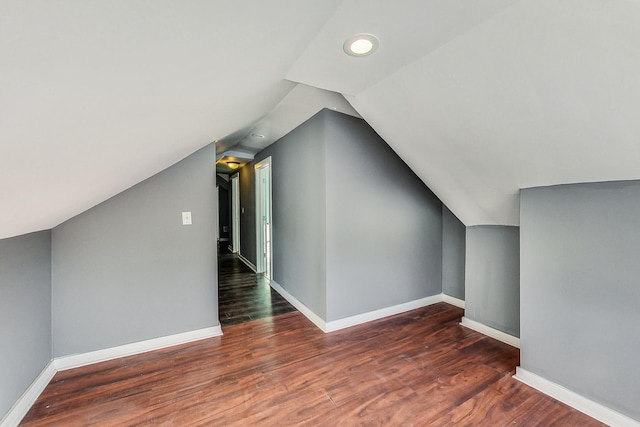 additional living space featuring vaulted ceiling and dark hardwood / wood-style floors