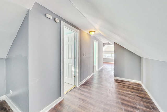 additional living space with vaulted ceiling and wood-type flooring