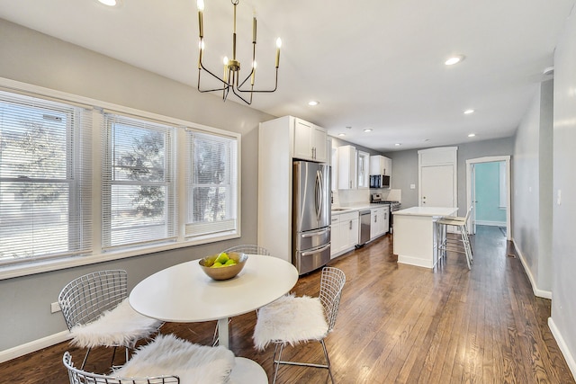 dining area featuring a notable chandelier and dark hardwood / wood-style flooring