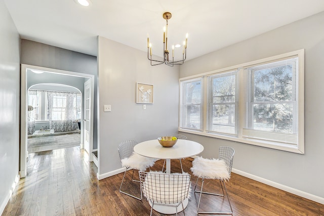 dining space featuring hardwood / wood-style flooring and a chandelier