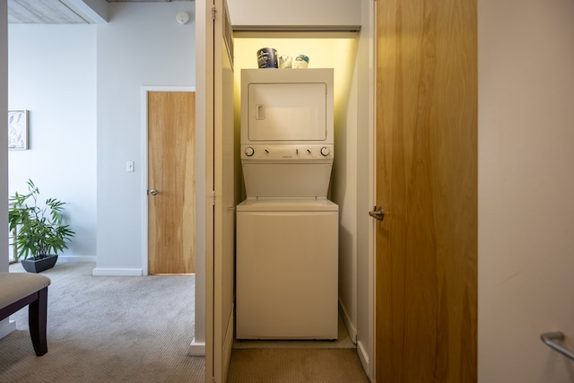 clothes washing area featuring light carpet and stacked washer / drying machine