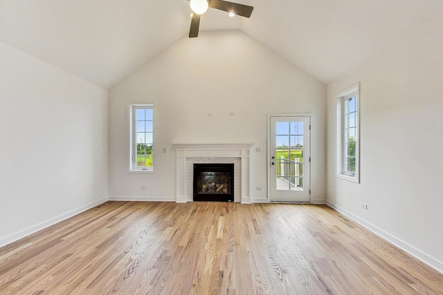 unfurnished living room with light wood-type flooring, a fireplace, and plenty of natural light