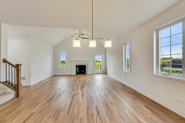 unfurnished living room with vaulted ceiling and light hardwood / wood-style floors