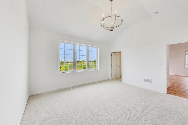 empty room with a notable chandelier, lofted ceiling, and light carpet