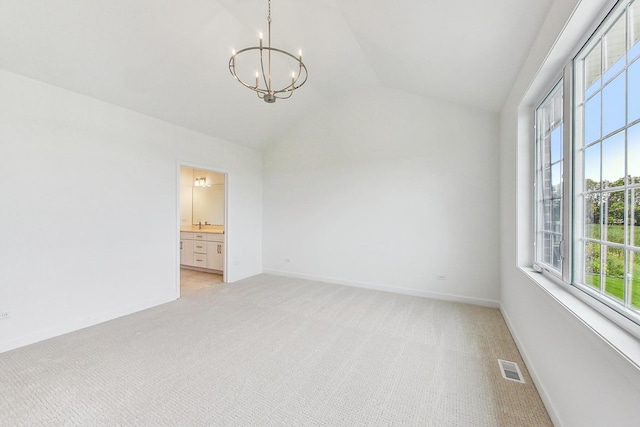 unfurnished room featuring a notable chandelier, light colored carpet, and vaulted ceiling