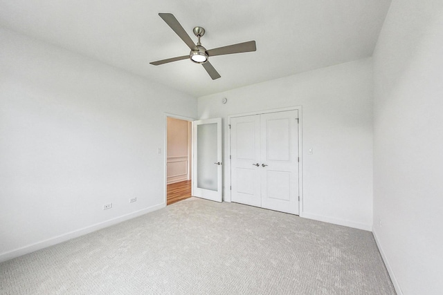 unfurnished bedroom featuring ceiling fan, a closet, and carpet