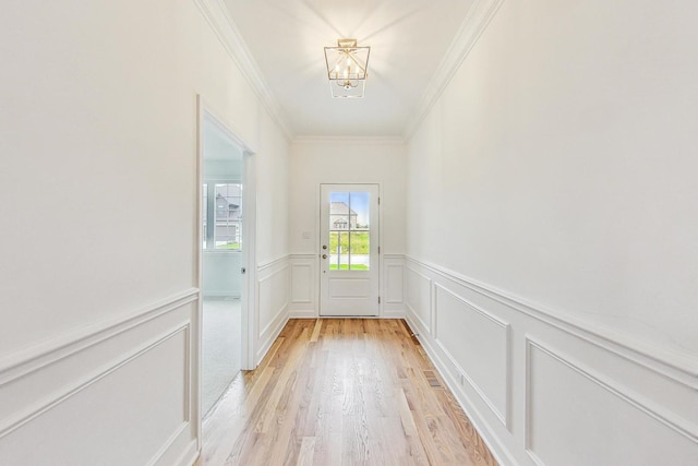 doorway to outside with crown molding and light wood-type flooring