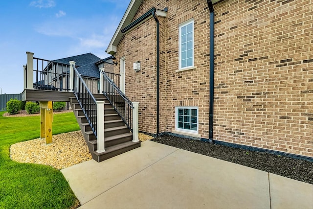 view of side of property with a patio, a yard, and a deck