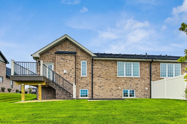 rear view of house with a deck and a yard