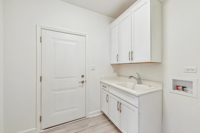 laundry room with hookup for a washing machine, cabinets, and sink