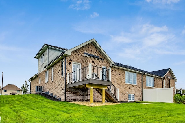 rear view of property with a yard, a deck, and cooling unit