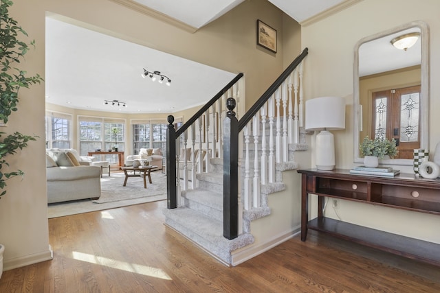 staircase featuring hardwood / wood-style floors and crown molding