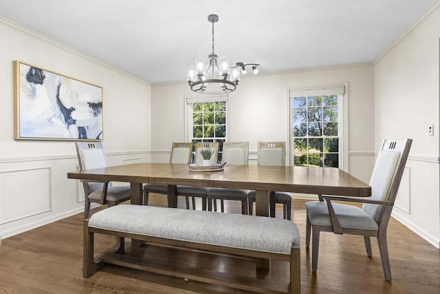 dining area featuring an inviting chandelier, ornamental molding, and dark hardwood / wood-style floors