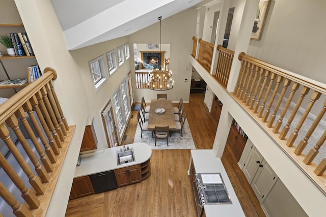 living room with dark hardwood / wood-style floors, a towering ceiling, sink, and a chandelier