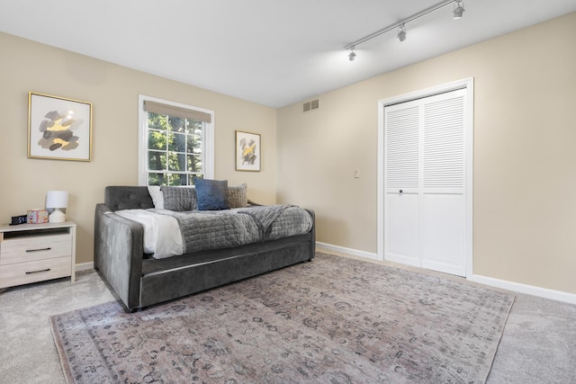 bedroom featuring light colored carpet and a closet