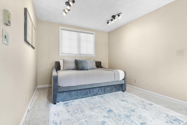 carpeted bedroom featuring rail lighting