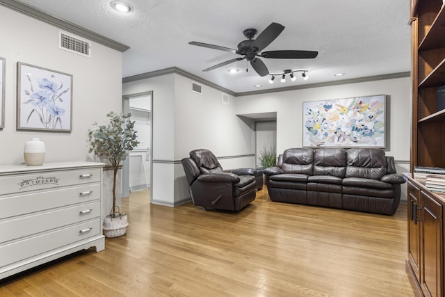 living room featuring ceiling fan, crown molding, light hardwood / wood-style flooring, and a textured ceiling