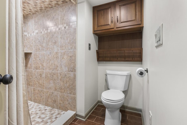 bathroom with tiled shower and toilet