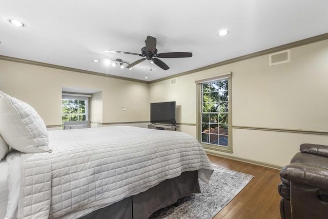 bedroom with ornamental molding, dark hardwood / wood-style floors, and ceiling fan