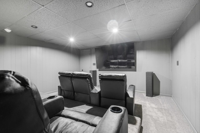 carpeted home theater with a drop ceiling