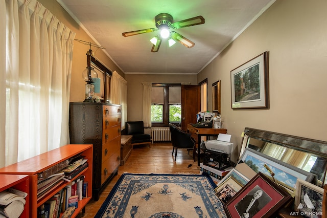 home office with ceiling fan, radiator, crown molding, and wood-type flooring