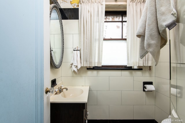 bathroom featuring tile walls, toilet, and vanity