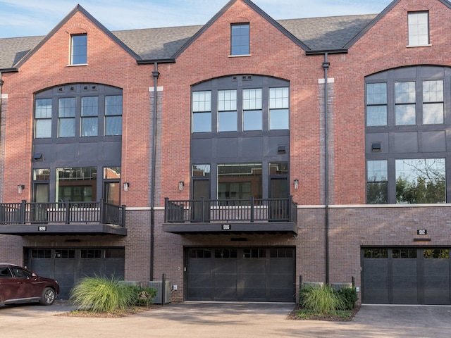 view of property featuring central AC, a garage, and a balcony